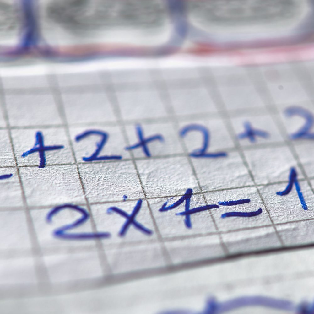 Checkered notebook with mathematical calculations of a child