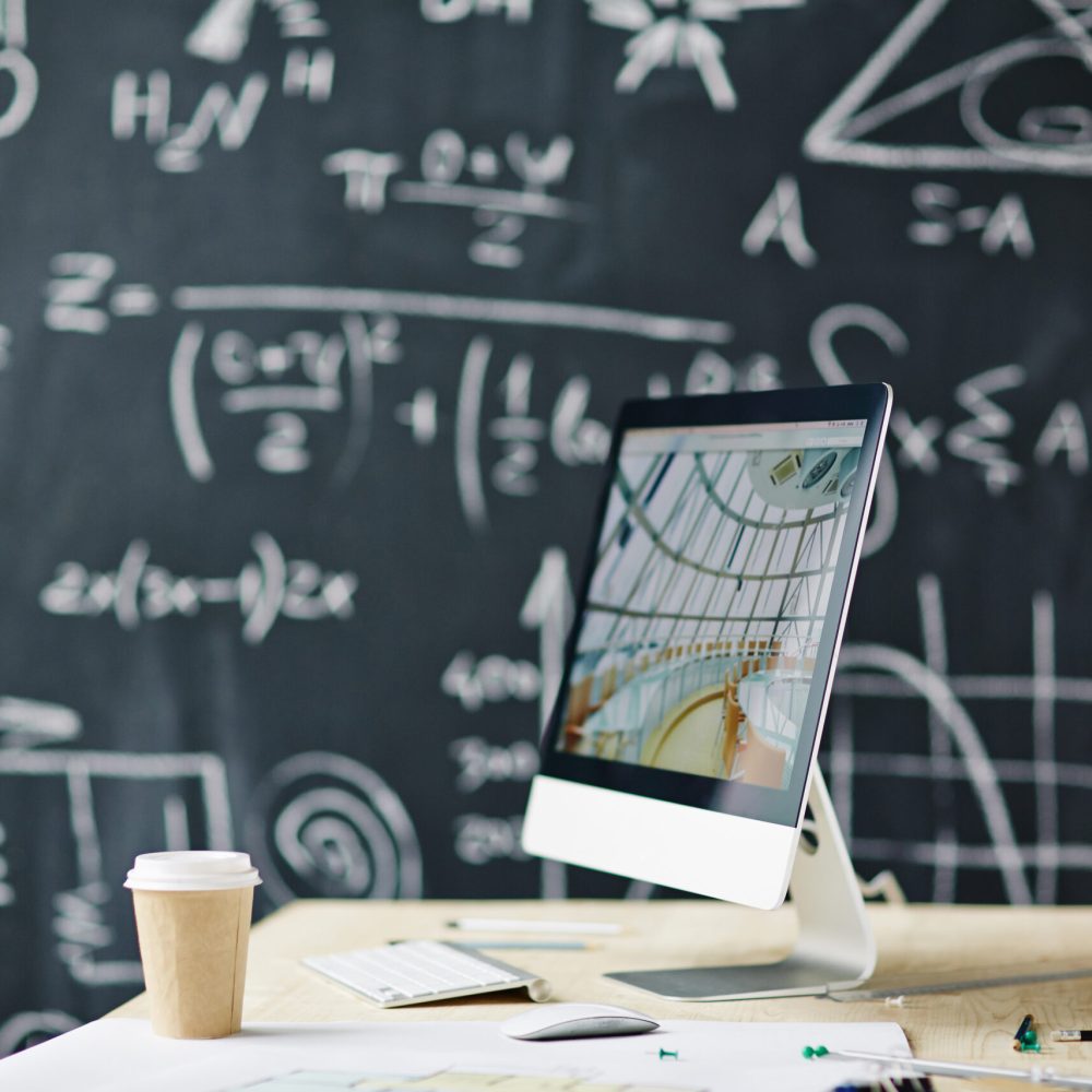 Computer on the table with blackboard in the background